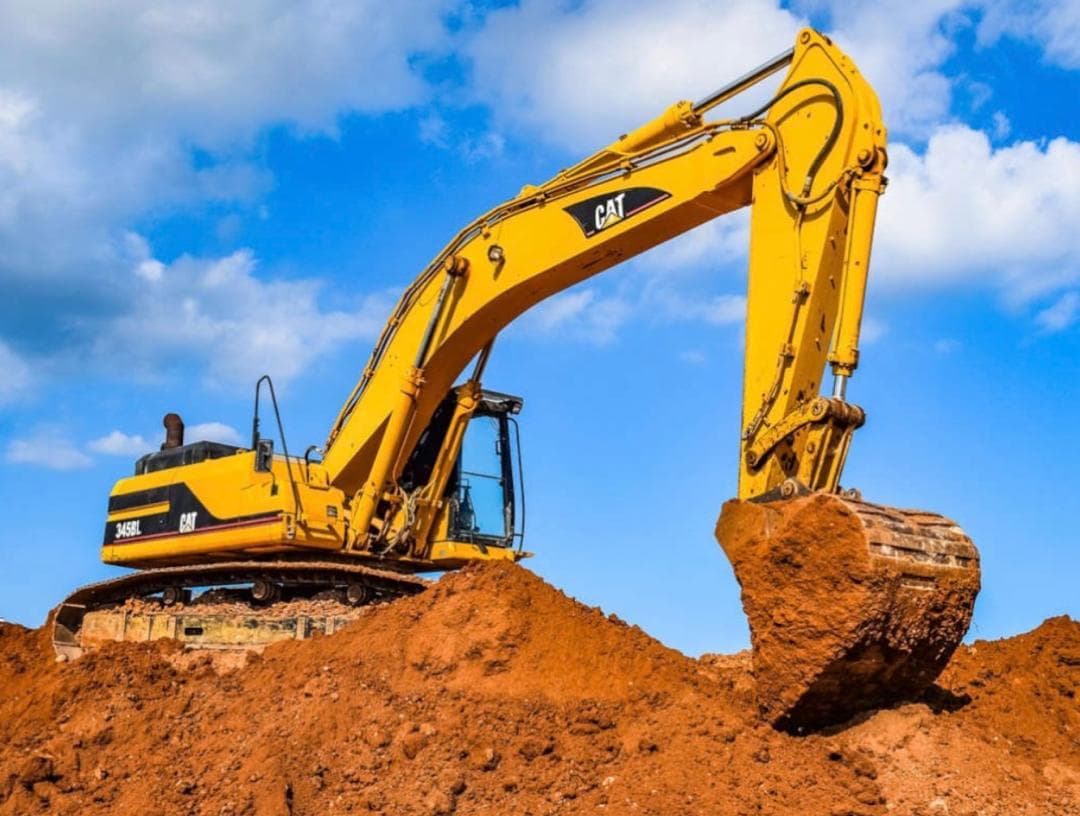Caterpillar 345B L excavator with bucket raised over a stockpile