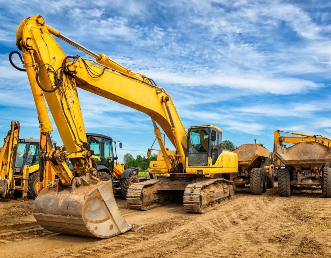 Excavator with a backhoe loader and two articulated dumpers behind it